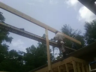 Carpenter setting a ridge beam over a new addition frame — Ice Dam Removal by Roofing Brothers in Crystal Bay