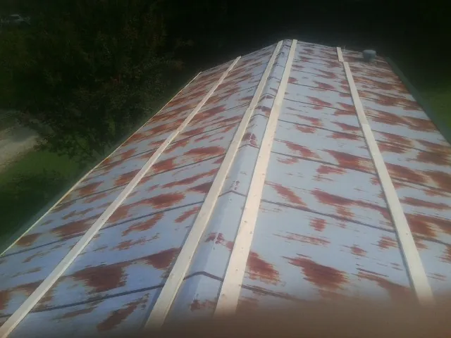 Rusted metal roof panels with new wood purlins before replacement — Storm Damage Roof Repair in Crystal Bay by Roofing Brothers