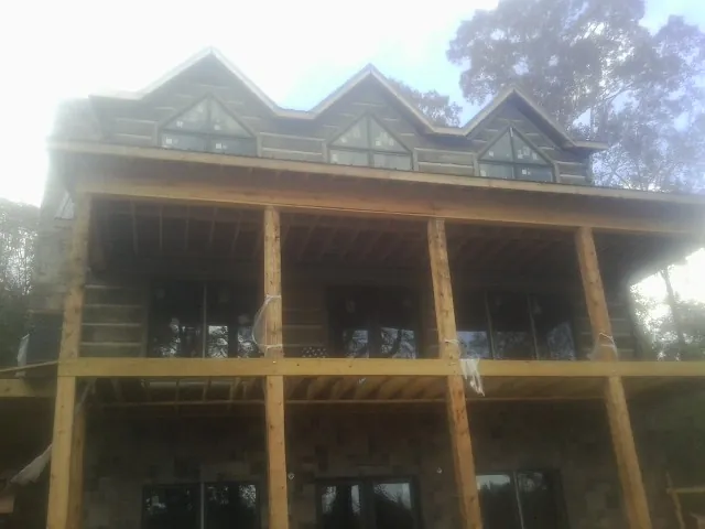 Dormers and porch framing on a large log home under construction — Roof Coating work by our crew in Crystal Bay