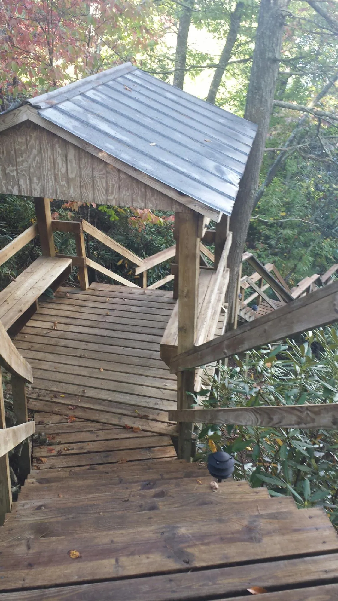 Metal roofed shelter over wooden steps on a wooded walkway — Skylight Repair & Installation work by our crew in Crystal Bay